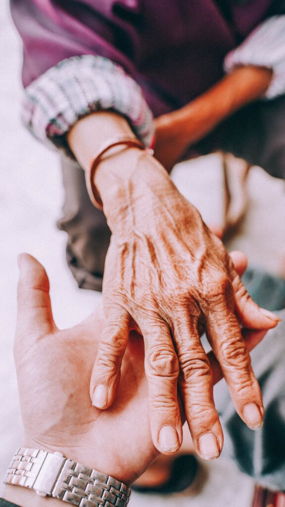 pexels photo 14441380 14441380 Close-up of a senior's hand being held by a younger hand, symbolizing care and connection.