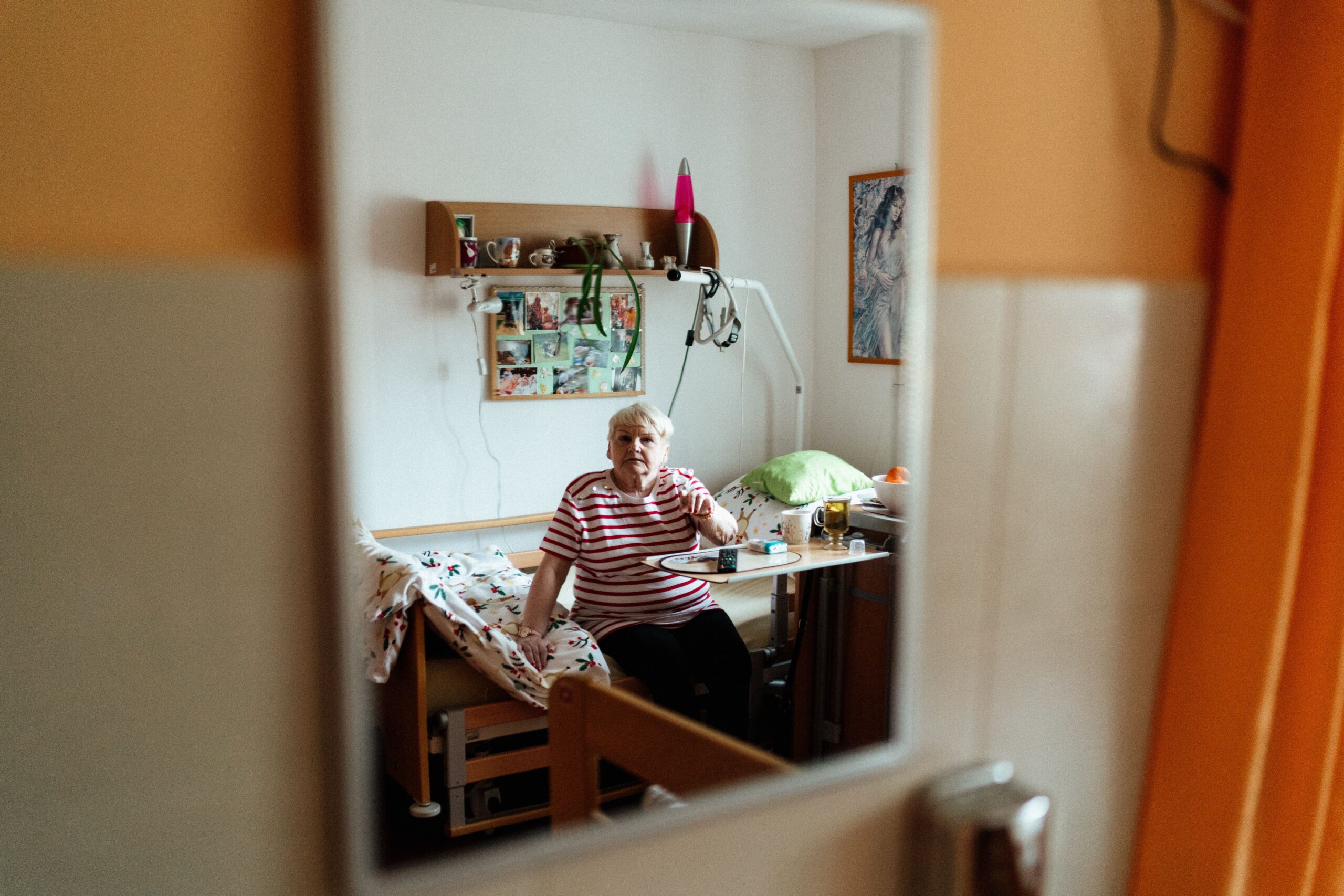 Pflegegrad Und Treppenlift 2026: Welche Leistungen Und Zuschüsse Gibt Es? Elderly woman reflecting in mirror, sitting in a cozy room. Warm and intimate setting.