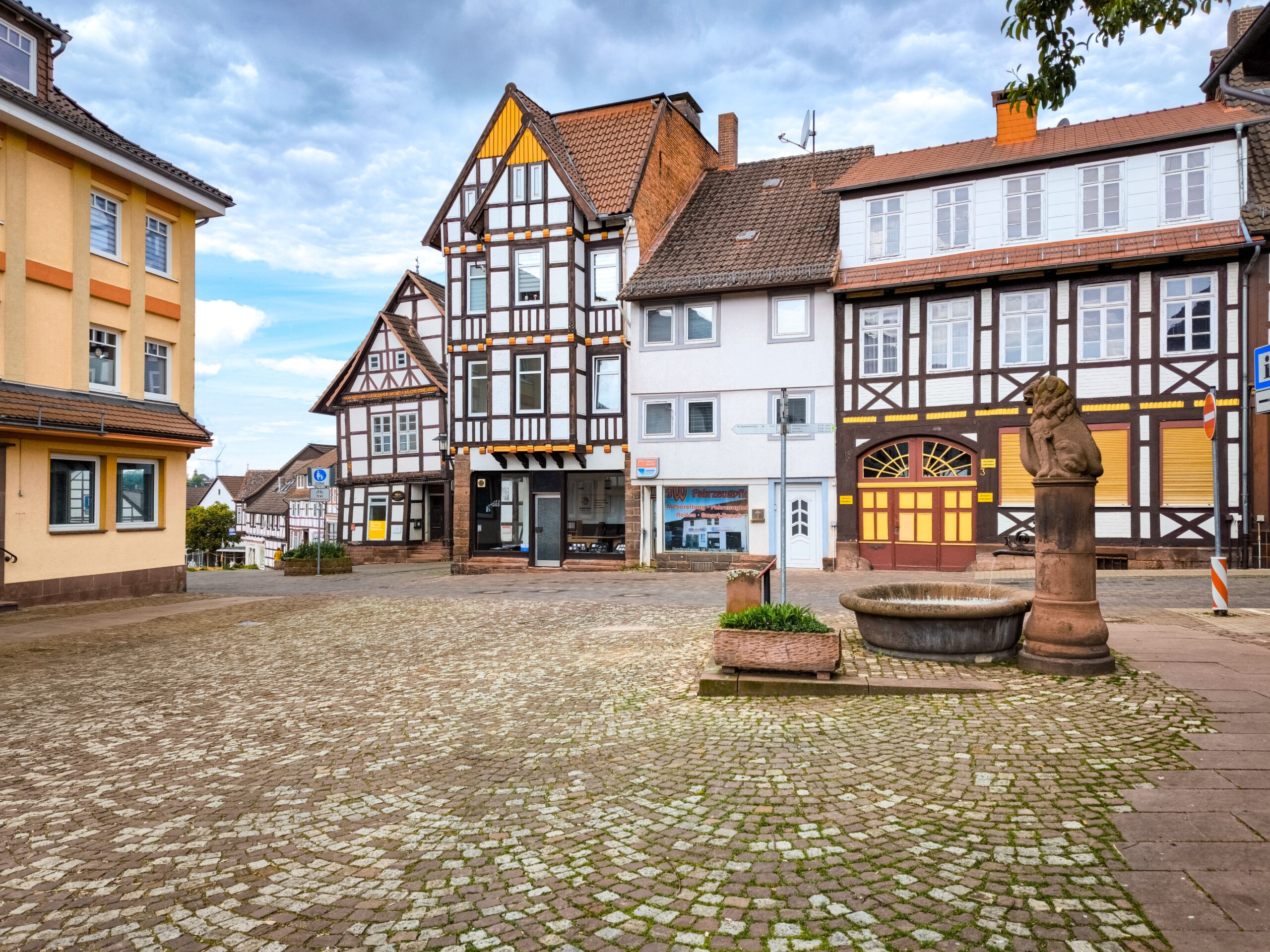 Quaint cobblestone square with traditional European architecture in a serene setting.