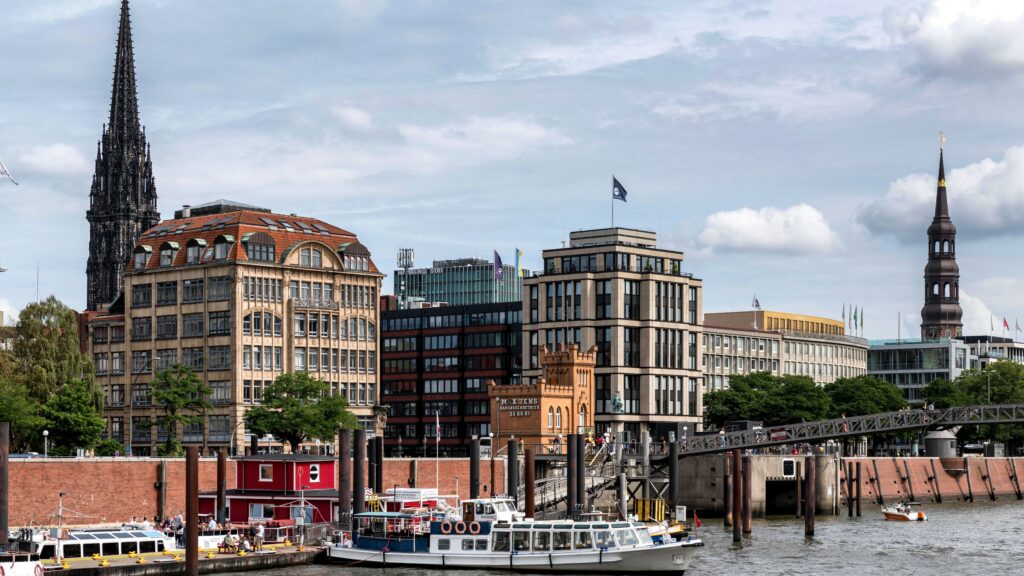 Panoramic view of Hamburg's iconic skyline and harbor with boats.