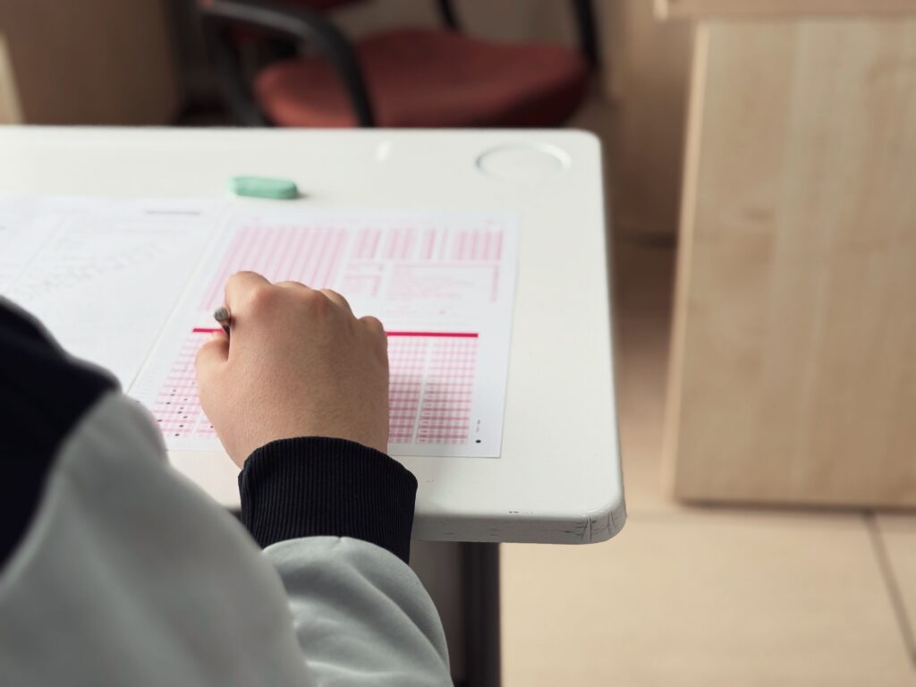 pexels photo 31115182 31115182 Close-up of student answering a test in a classroom environment.