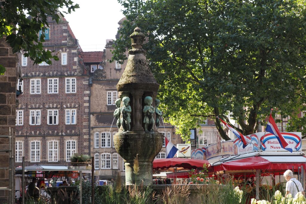 pexels photo 31430403 31430403 Charming fountain amidst vibrant market stalls in scenic Bremen, Germany.