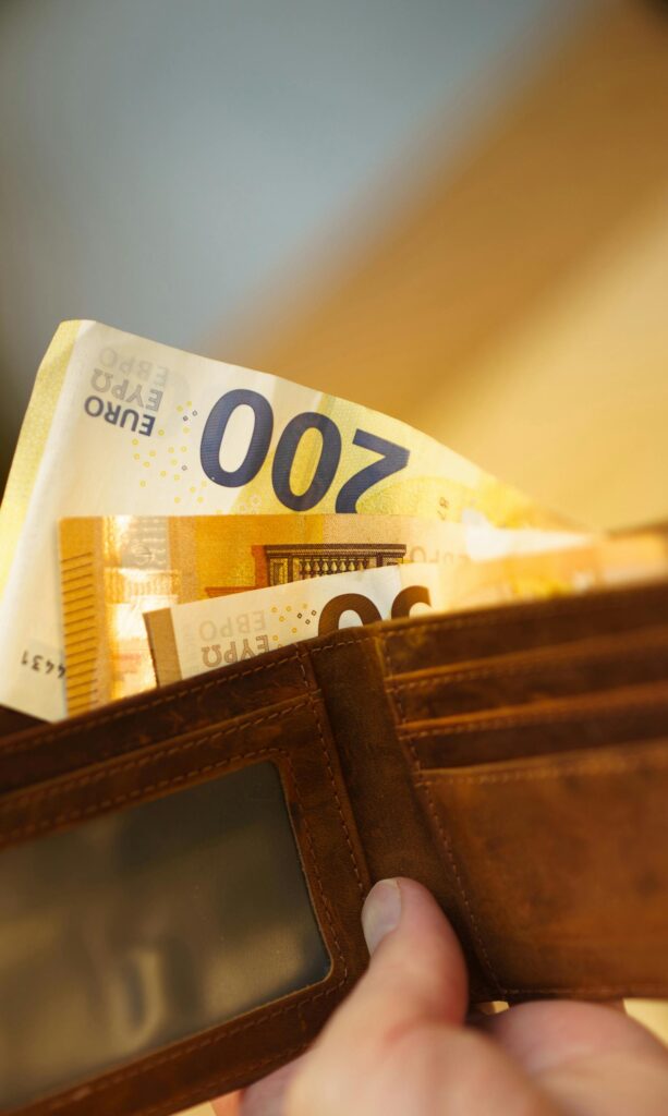 pexels photo 31550977 31550977 Close-up of a hand holding a leather wallet filled with 200 euro banknotes, highlighting finance and economy.