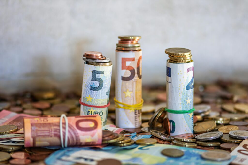 pexels photo 34637758 34637758 Close-up of rolled Euro banknotes and coins on a table, symbolizing finance and savings.