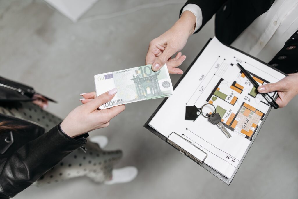 pexels photo 7937717 7937717 Close-up of a real estate transaction with euro bill, keys, and floor plan.