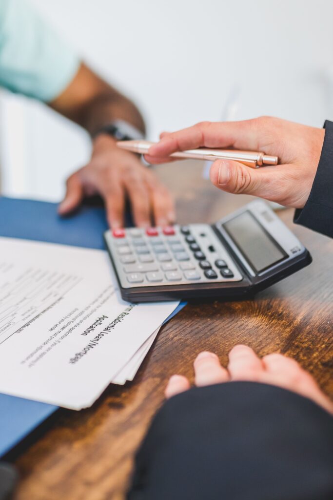 pexels photo 8292798 8292798 Hands working with a calculator and documents at a business meeting.