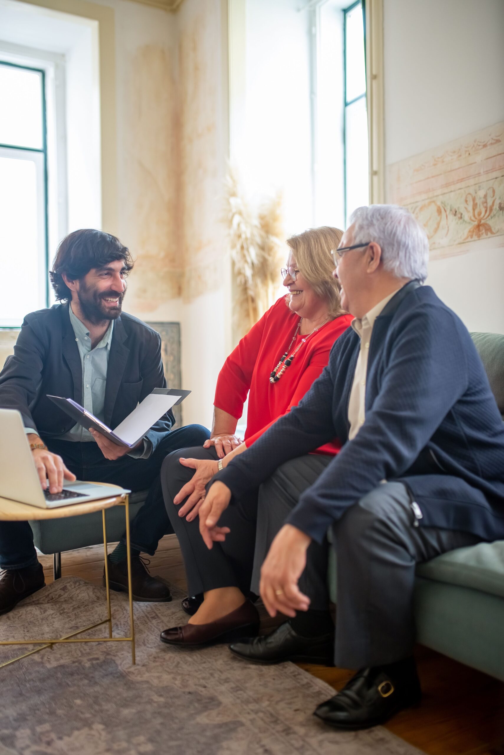 Treppenlift-Beratung im Saarland – Kompetente Unterstützung für die richtige Entscheidung A professional business consultation with a senior couple and advisor indoors.