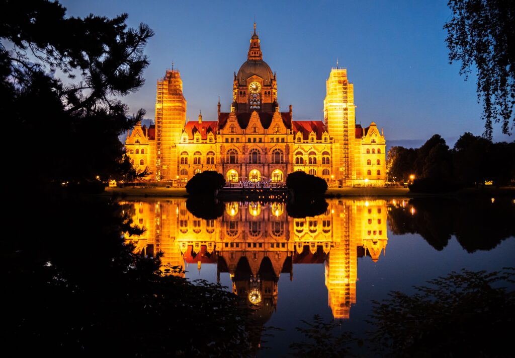 pexels photo 9129106 9129106 Stunning view of Hannover's New Town Hall illuminated at night, reflecting on tranquil water.