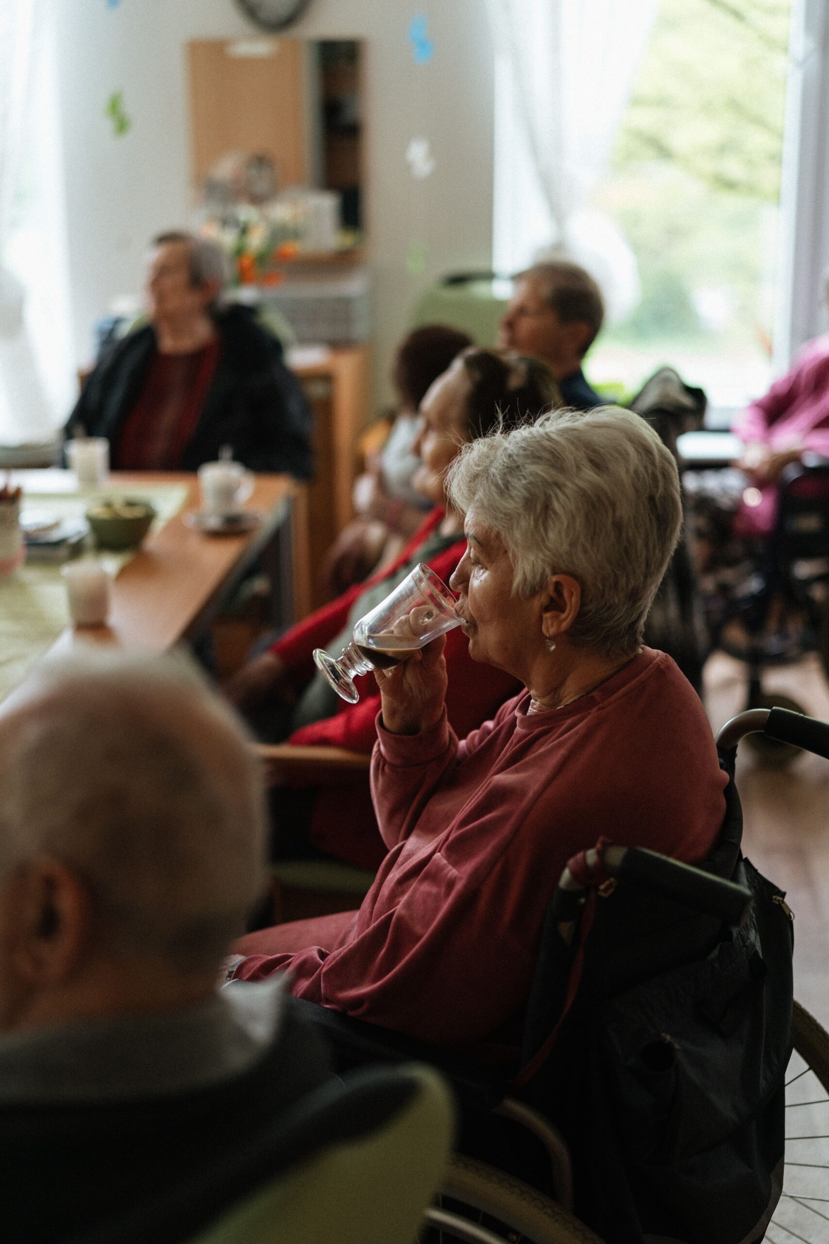 Treppenlift vor Pflegegrad Gelsenkirchen – Lohnt sich der Einbau? A cozy indoor gathering of elderly individuals enjoying coffee together.