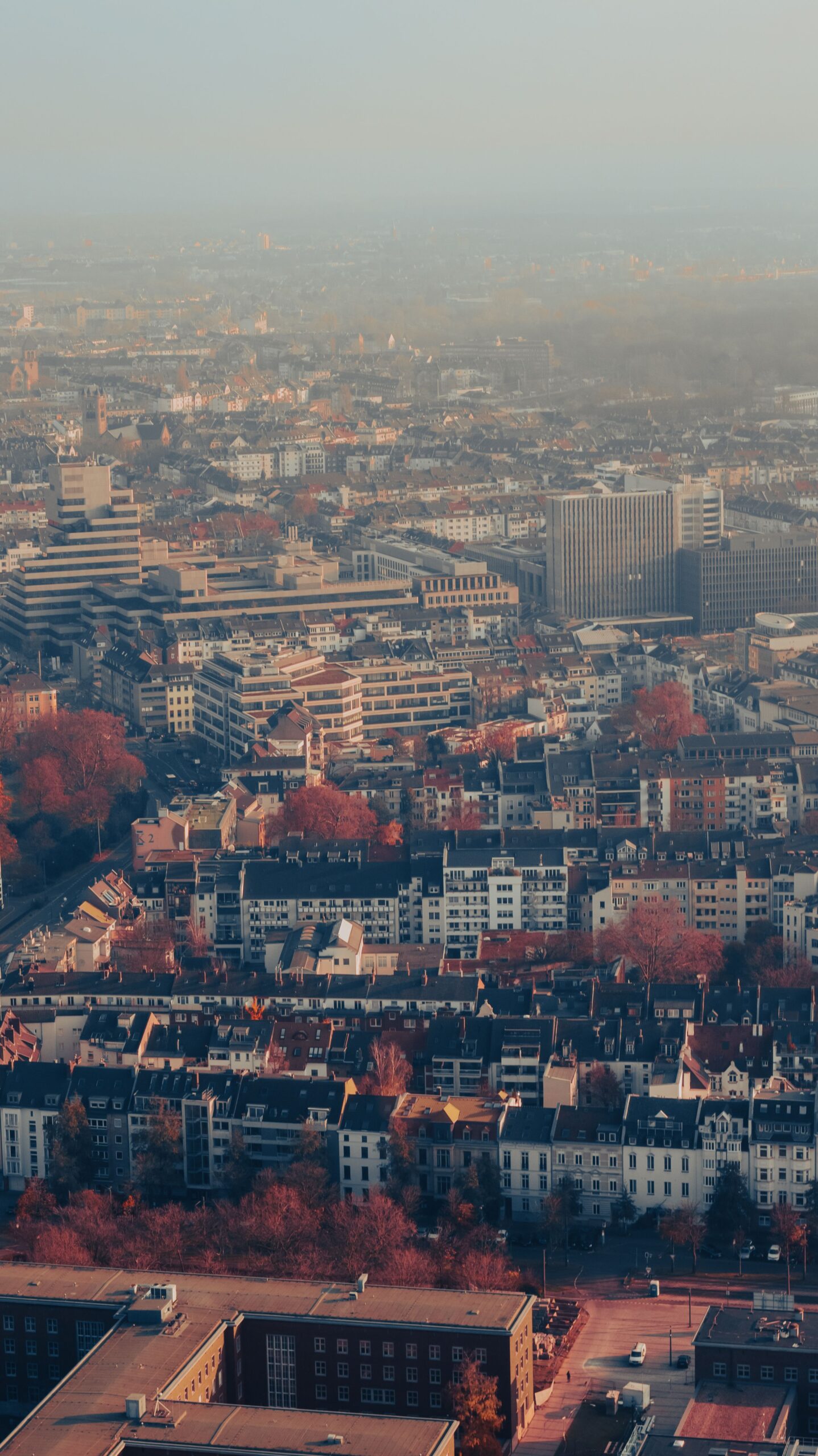 Treppenliftarten in Düsseldorf 2026: Welche Optionen stehen zur Verfügung? Overhead view of Düsseldorf city covered in fog and autumn hues, capturing urban landscape.
