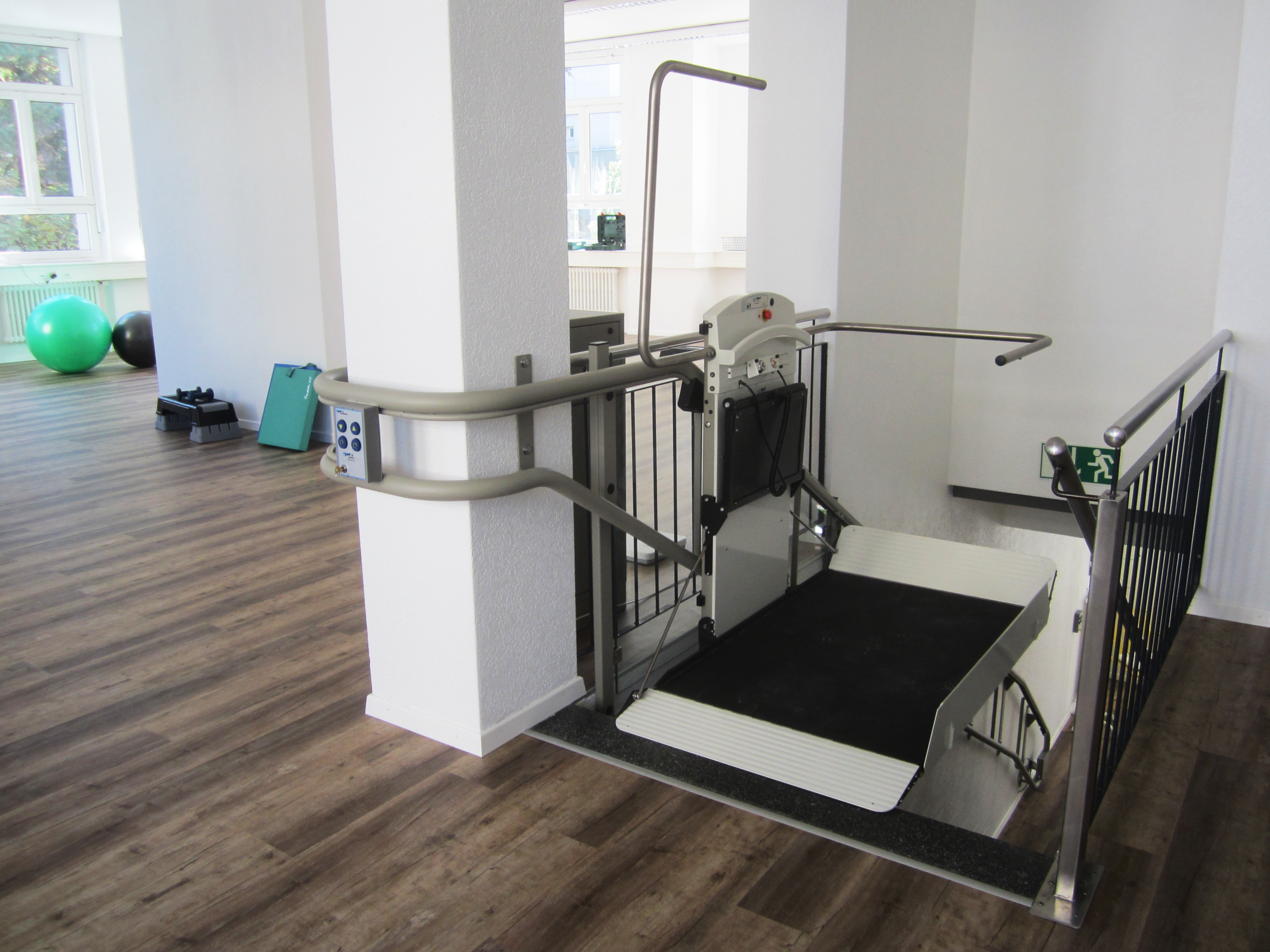 Hublift und Plattformlift: Technische Vergleichsübersicht für Rollstuhlfahrer Platform lift in a rehabilitation facility promoting handicap accessibility and mobility aid support.